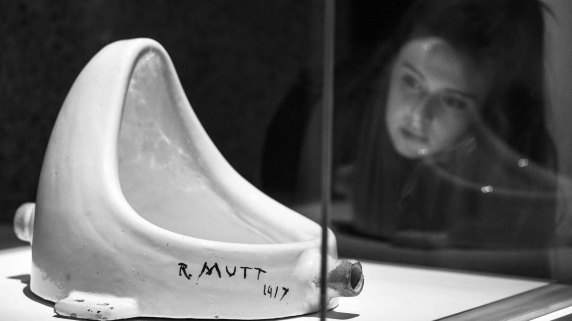 Una chica observa en una vitrina La Fuente de Marcel Duchamp